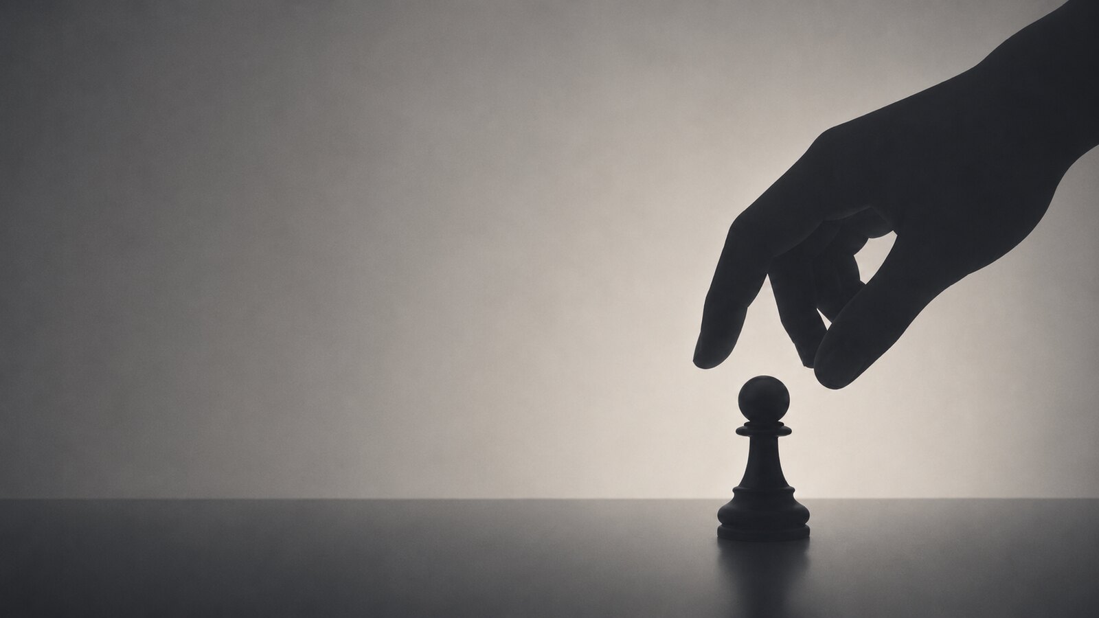 A hand reaching down to move a lone chess pawn